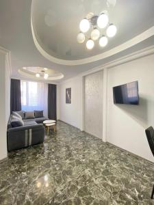 Una sala de estar con un sofá y un televisor. en Modern apartment nice view at Republic Squer, en Ereván