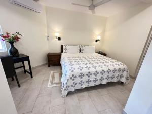 Un dormitorio con una cama y una mesa con un jarrón de flores. en Karana Suite One Bedroom - K3, en Long Bay Hills 77 fotos más