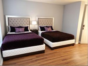 a bedroom with two beds with purple pillows at Art District Downtown Spacious Homes in Los Angeles