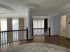 a white room with a staircase and windows at B&B Apartment Farhad Hospitality Solutions in Samarkand