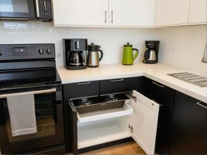 a kitchen with black appliances and white cabinets at Art District Downtown Spacious Homes in Los Angeles +68 photos