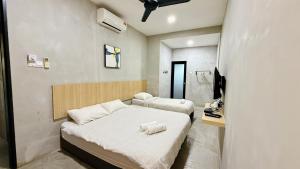 a bedroom with two beds and a television in it at Leisure29 Suites in Kuantan +34 photos