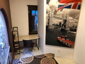 a room with a desk and a painting on the wall at Roomies Hostel - Roma in Mexico City