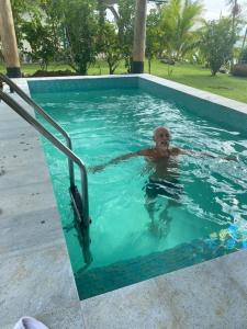 a man swimming in a swimming pool at The Pointe Taveuni in Matei