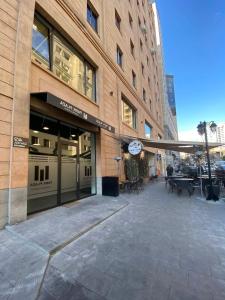 una tienda frente a un edificio con mesas y sillas en Modern apartment nice view at Republic Squer, en Ereván