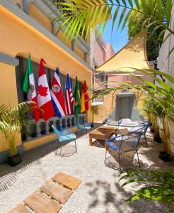 a patio with chairs and flags on a building at Roomies Hostel - Roma in Mexico City