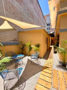 a patio with chairs and a table on a building at Roomies Hostel - Roma in Mexico City +40 photos