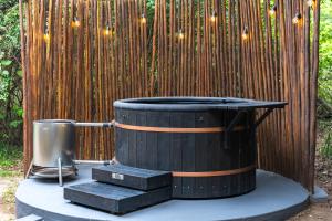 a wooden fence with a hot tub in front of a barrel at The Cabin Luxury Safari Villa, Private Pool, Hot tub, Outdoor Shower, Giraffe Tower, Free Standing Bath, Private Game Reserve, Romantic Getaway, Ultimate Bush Luxury in Hluhluwe