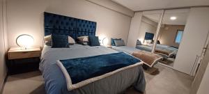 Un dormitorio con una cama grande con cabecero azul. en Appartement entre Sisteron et Gorges de la Méouge " Les Hauts de Toscane ", en Ribiers