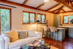a living room with a couch and a kitchen at The Cabin Luxury Safari Villa, Private Pool, Hot tub, Outdoor Shower, Giraffe Tower, Free Standing Bath, Private Game Reserve, Romantic Getaway, Ultimate Bush Luxury in Hluhluwe