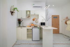 a kitchen with white cabinets and a white refrigerator at Four P Home and Studio in Ho Chi Minh City