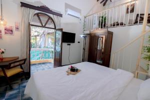 卡兰古特Goan Portuguese house in Calangute - Casa De HAC的一间卧室，有一张白色的床和一扇窗户