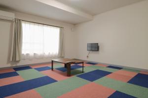 a room with a table and a television in it at スマートハウスみづほ in Hitoyoshi