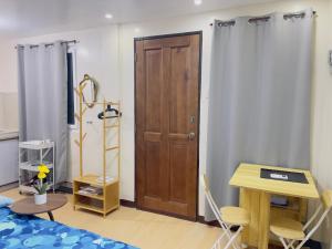 a bedroom with a wooden door and a table and chairs at Potot Haven Dorm and Transient in Libmanan