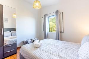une chambre blanche avec un lit et une fenêtre dans l'établissement Casa Miguel, à Machico