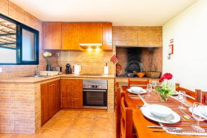 une cuisine avec des placards en bois et une table avec des assiettes. dans l'établissement Casa Miguel, à Machico 21 autres photos