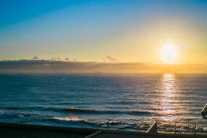 una vista del océano al atardecer desde un crucero en Celestial Shore- Main Tidal Beach- Aircon -Dstv- BBQ, en Umdloti