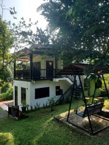 Casa con balcón y columpio en Jungle House, en Unawatuna
