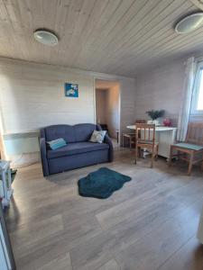 a living room with a blue couch and a table at Kanadyjka in Lubień Kujawski