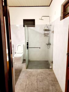 Un baño con ducha y WC. en Jungle House, en Unawatuna