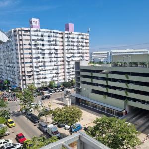 ein großes Gebäude mit auf einem Parkplatz abgestellten Autos in der Unterkunft Popular Muang Thong Condo, Building T9, Floor 8, Room 20 in Ban Bang Phang