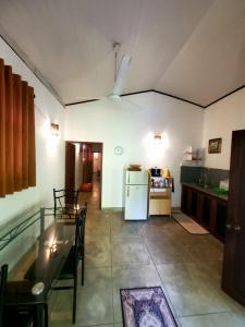 Una cocina con una mesa y un refrigerador blanco. en Jungle House, en Unawatuna 6 fotos más