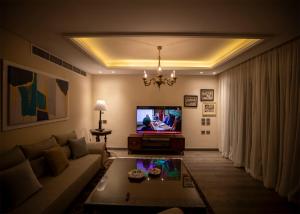 a living room with a couch and a tv at Pyramids Gem in Kafr Ghaţāţī