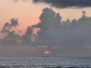 Myna beach stay في جوكارنا: قارب في المحيط تحت السماء الغائمة