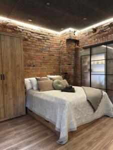 ein Schlafzimmer mit einem großen Bett mit Ziegelwand in der Unterkunft Casa Rustica Free Parking Port Arthur in Turku