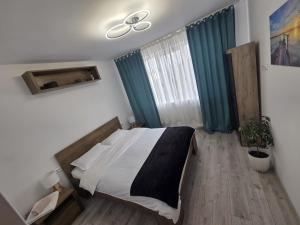 a bedroom with a bed and a ceiling fan at NGR Residence in Ploieşti
