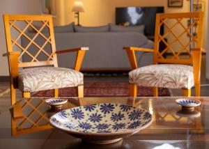 a living room with a glass table and two chairs at Pyramids Gem in Kafr Ghaţāţī