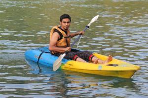 a man sitting on a kayak in the water at Green view resort in Dandeli