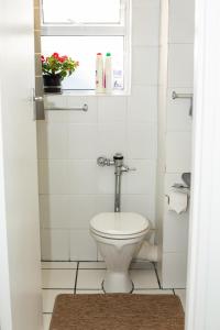 ein Badezimmer mit Toilette und Fenster in der Unterkunft Cascades apartments in Kapstadt + 7 Fotos