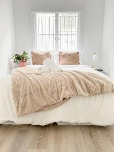 Brisbane CBD - 2BR - Sleeps 6 - Snacks WIFI - Parking في بريزبين: غرفة نوم بسرير كبير مع شراشف بيضاء ونافذة