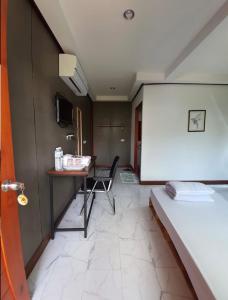 a room with a desk and a bed and a table at We Home Guesthouse in Ban Pa Bong