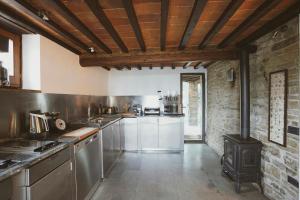 a large kitchen with a wood stove in it at Historic Villa Among Olive Groves In Arezzo in San Polo