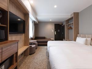a hotel room with a bed and a flat screen tv at The OneFive Osaka Namba Kuromon in Osaka +38 photos