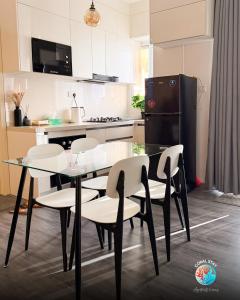 une cuisine avec une table, des chaises et un réfrigérateur dans l'établissement Coral Stay Rooms, à Hulhumalé