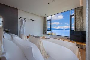 a bedroom with a tub and a large window at Blue Sea Hotel in Dali