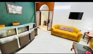 Una sala de estar con un sofá amarillo y una pecera. en ES tower, en Gumgaon