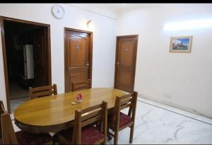 Un comedor con mesa y sillas de madera. en ES tower, en Gumgaon