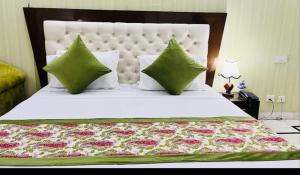 Un dormitorio con una cama grande con almohadas verdes. en ES tower, en Gumgaon 6 fotos más