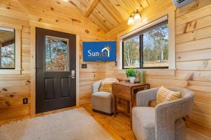 a sunlit room with two chairs and a door at P-Bay The Roost home in Reeds Spring
