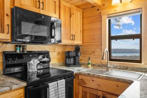 a kitchen with a stove microwave and a sink at P-Bay The Roost home in Reeds Spring