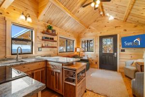 a log cabin kitchen with a sink and a couch at P-Bay The Roost home in Reeds Spring
