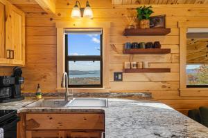 a kitchen with wooden walls and a sink and two windows at P-Bay The Roost home in Reeds Spring +30 photos