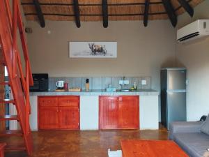 a kitchen with red cabinets and a counter top at Vakasha Lodge in Siphofaneni