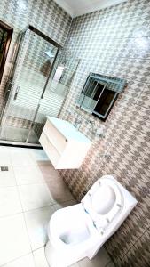 een badkamer met een toilet en een douche bij Kigali Beauty Homes in Kigali