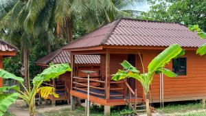 a small wooden house with a red roof at Umi Resort 菩提有米 in Sihanoukville