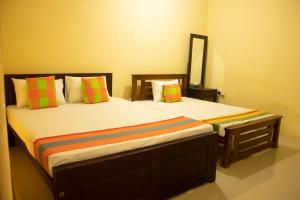 a bedroom with two beds with colorful pillows at Lishan Nature Resort - Kataragama in Gotamegama